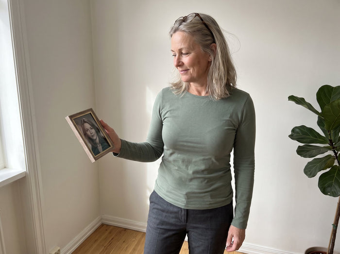 Frau um die 55 mit einem Foto von sich mit 30